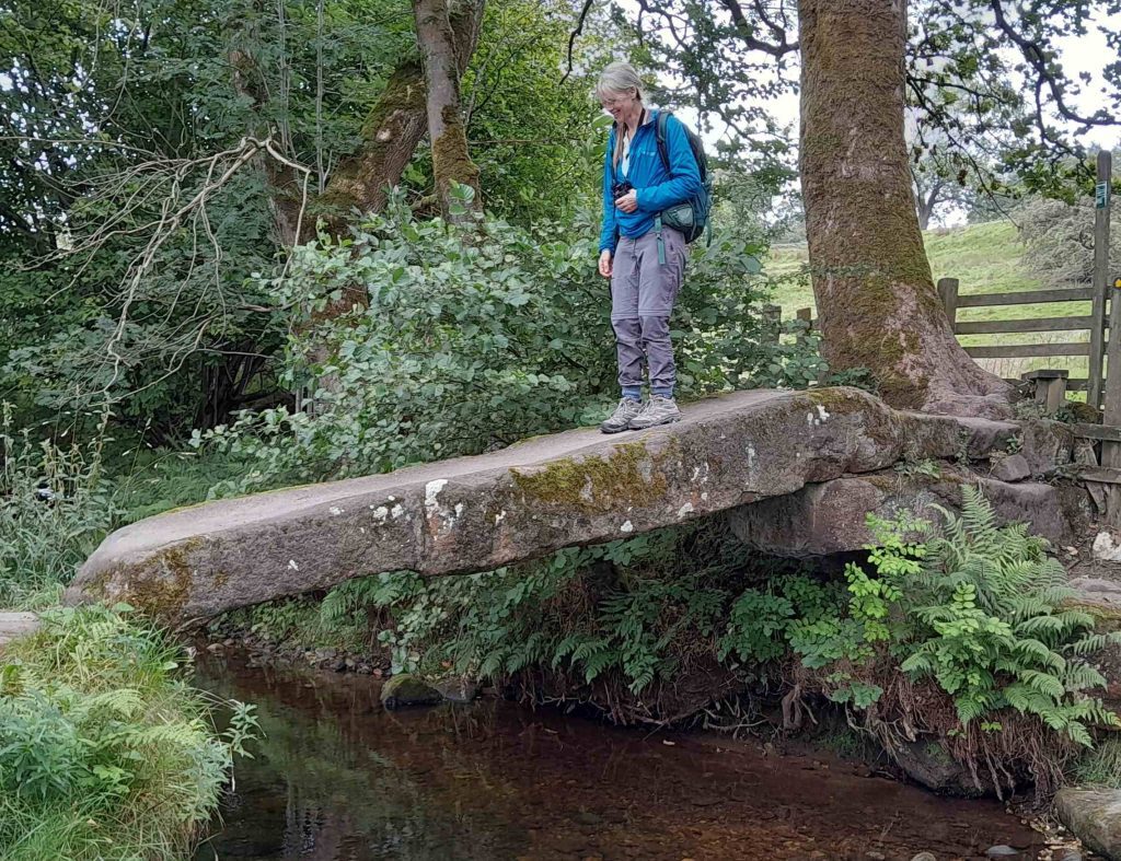 The clam bridge, the oldest of the 3 ancient bridges, a single stone slab laid across the stream at an angle. One of our group perched tentatively on it. 