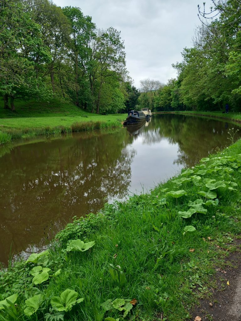 canal waterway on a still day with a canal boat in the distance