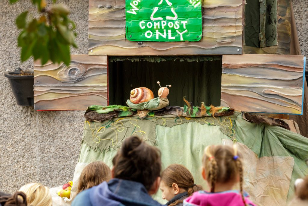 children watching a puppet show about compost.